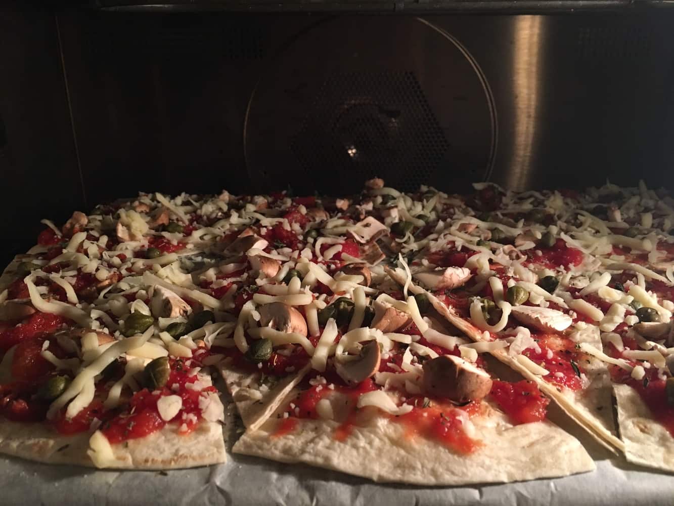 Voor als je geen miniwraps kunt vinden: knip voor lekkere pizzahapjes een grote wrap in pizzapunten.